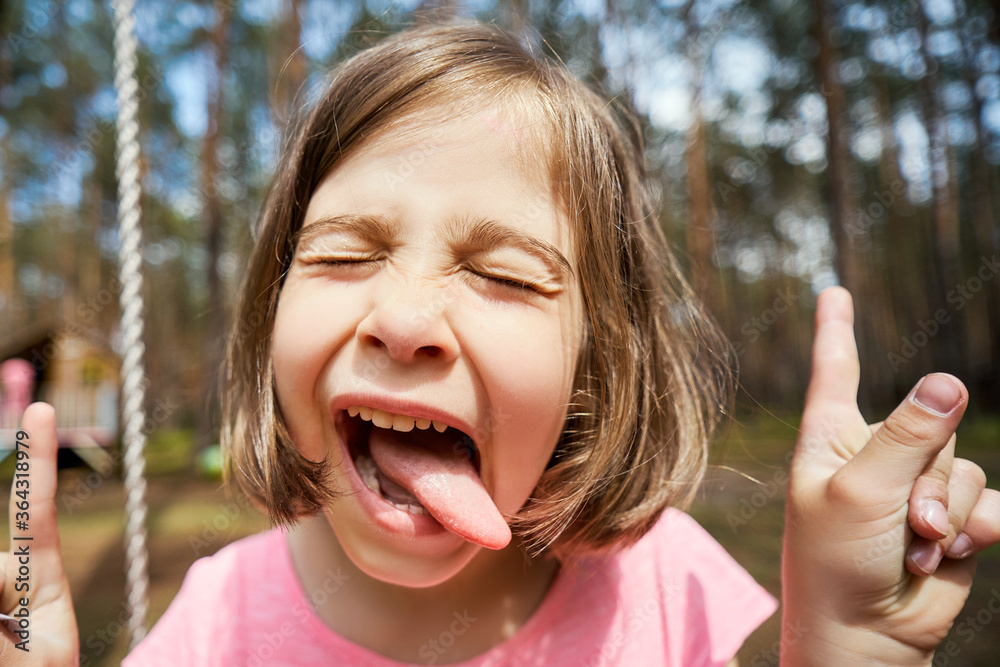adorable little girl sits on a swing and makes faces adorable little girl sits on a swing and makes faces