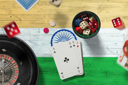 India casino theme. Aces in poker game, cards and chips on red table with national flag background. Gambling and betting. photo