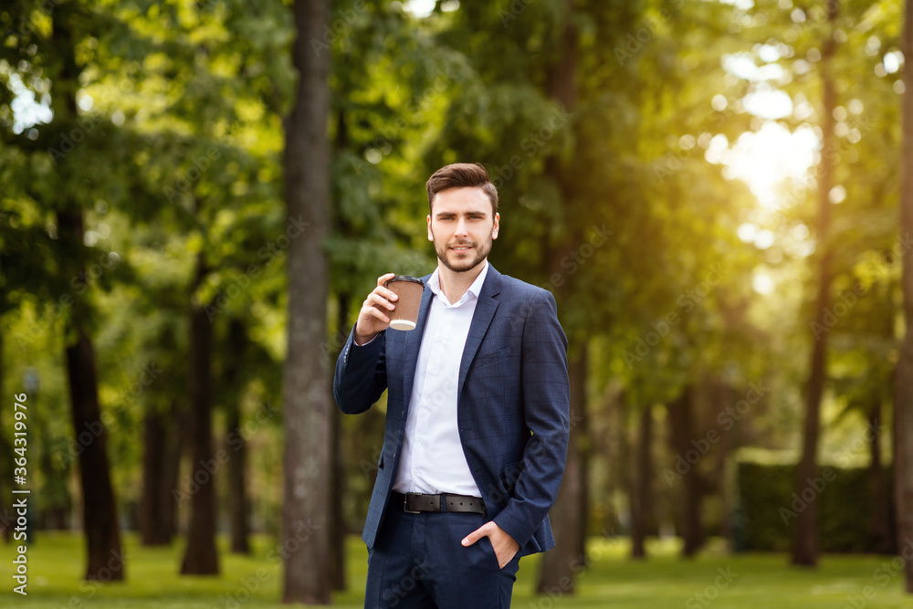 Professional business leader having coffee to go on his way to work at city park Professional business leader having coffee to go on his way to work at city park