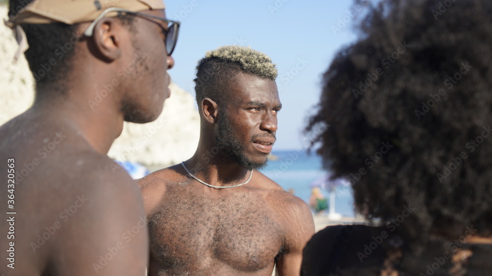 Portrait of african american friends standing outdoors along the beach Portrait of african american friends standing outdoors along the beach