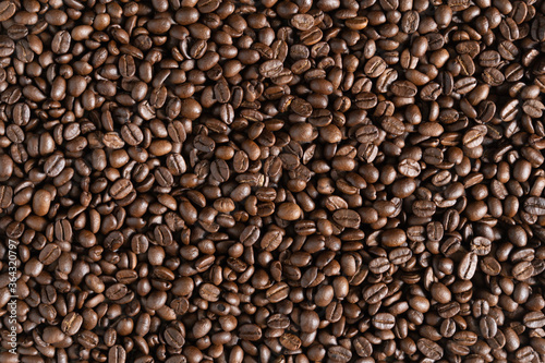 Roasted arabica coffee beans background on wooden table.Arabica coffee is the world's most popular type of coffee.