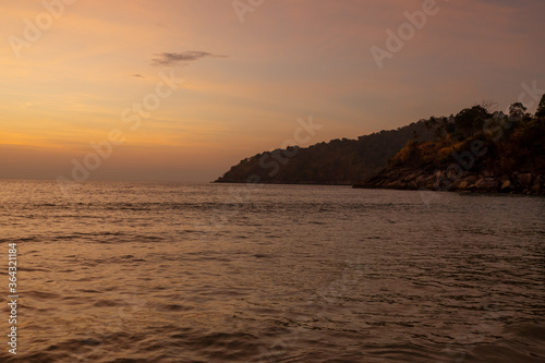 Landscape of sunset tropical beach with hills in the background in Phuket, Thailand