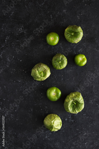 Vertical view of a bunch of green tomatoes in a dark background © Bruno Daniel