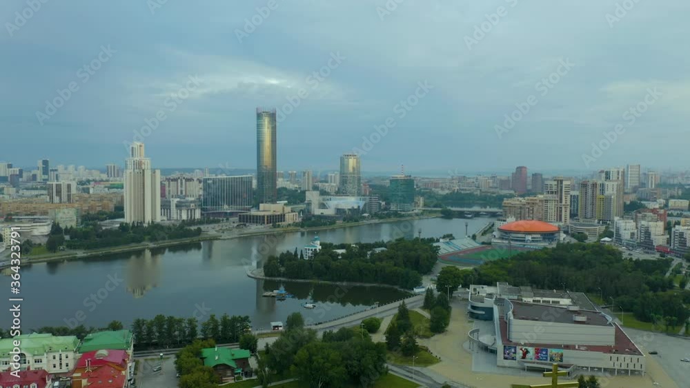 Aerial view of large russian city, buildings, trees near the river in summer sunny morning. Stock footage. Beautiful urban landscape. Aerial view of large russian city, buildings, trees near the river in summer sunny morning. Stock footage. Beautiful urban landscape.