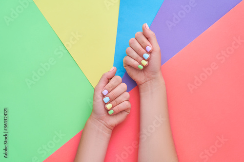 Female hands with bright summer colorful nails on a color background