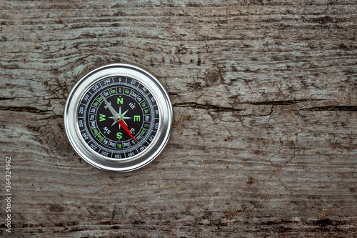 Silver compass on a wooden background top view. The concept of travel, leadership, help. Copy space. © Aliaksandr Marko