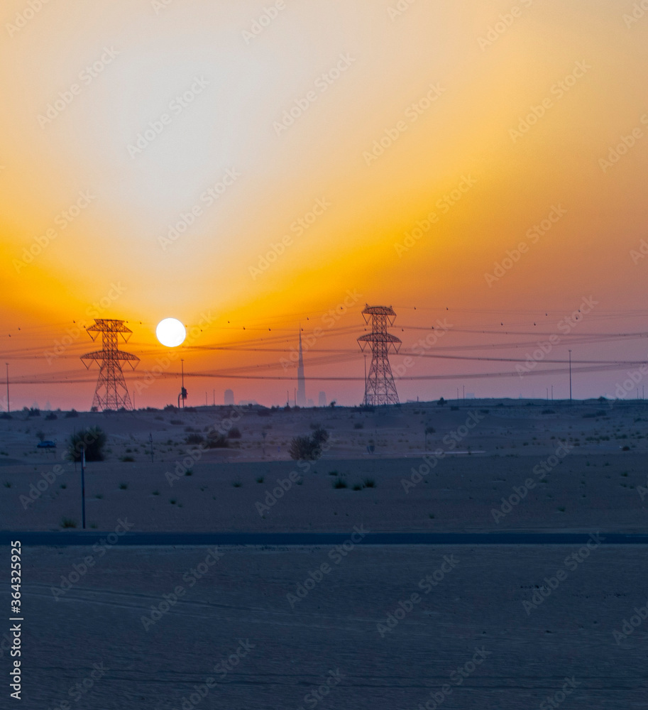 High voltage power lines in the desert during sunset