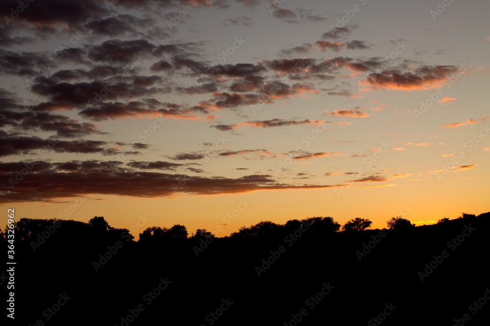 Sonnenuntergang über einer Baumreihe in Deutschland