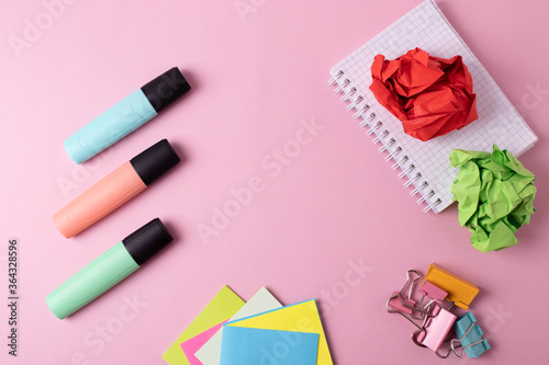 different colorful stationary items on a pink surface of a desk