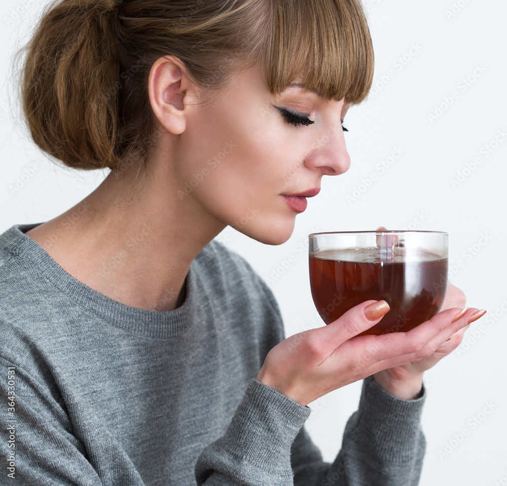 Young woman holds a cup of hot tea Young woman holds a cup of hot tea