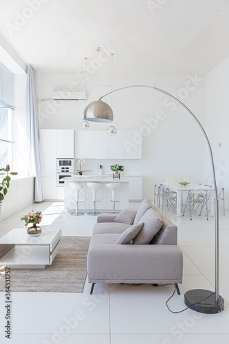 Cozy luxury modern interior design of a studio apartment in extra white colors with fashionable expensive furniture in a minimalist style. white tiled floor  kitchen  relaxation area and workplace