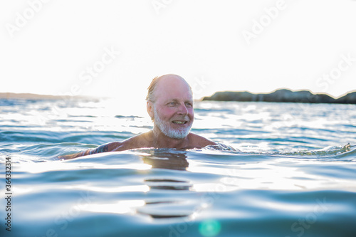 A very happy middle aged man swimming in the sea in Sweden
