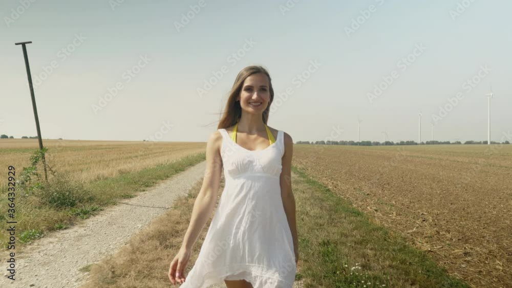 Woman walking down a path in summer Woman walking down a path in summer