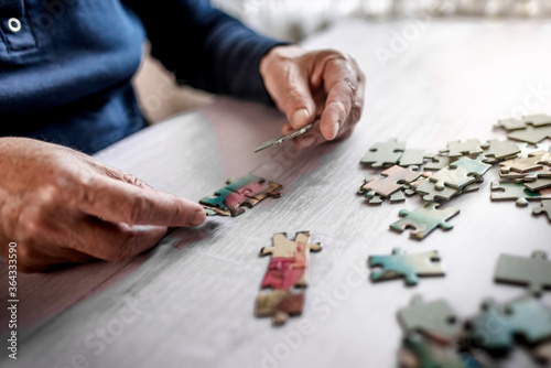 Senior person connecting jigsaw puzzles