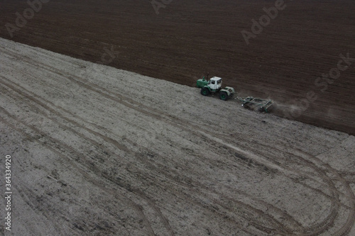 Tractor plows a field, aerial view. Agricultural landscape.