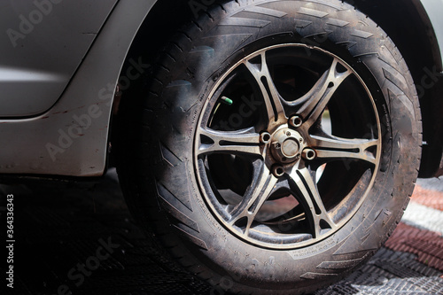 a wheel of a parked car.