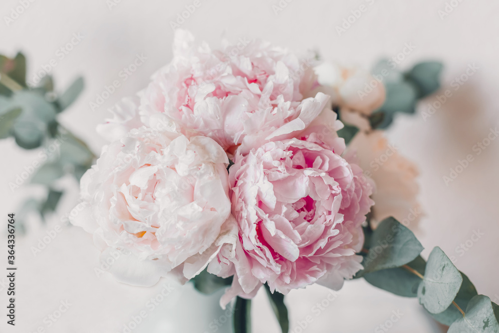 Delicate bouquet of peonies with eucalyptus branches in pastel colors selective focus Delicate bouquet of peonies with eucalyptus branches in pastel colors selective focus