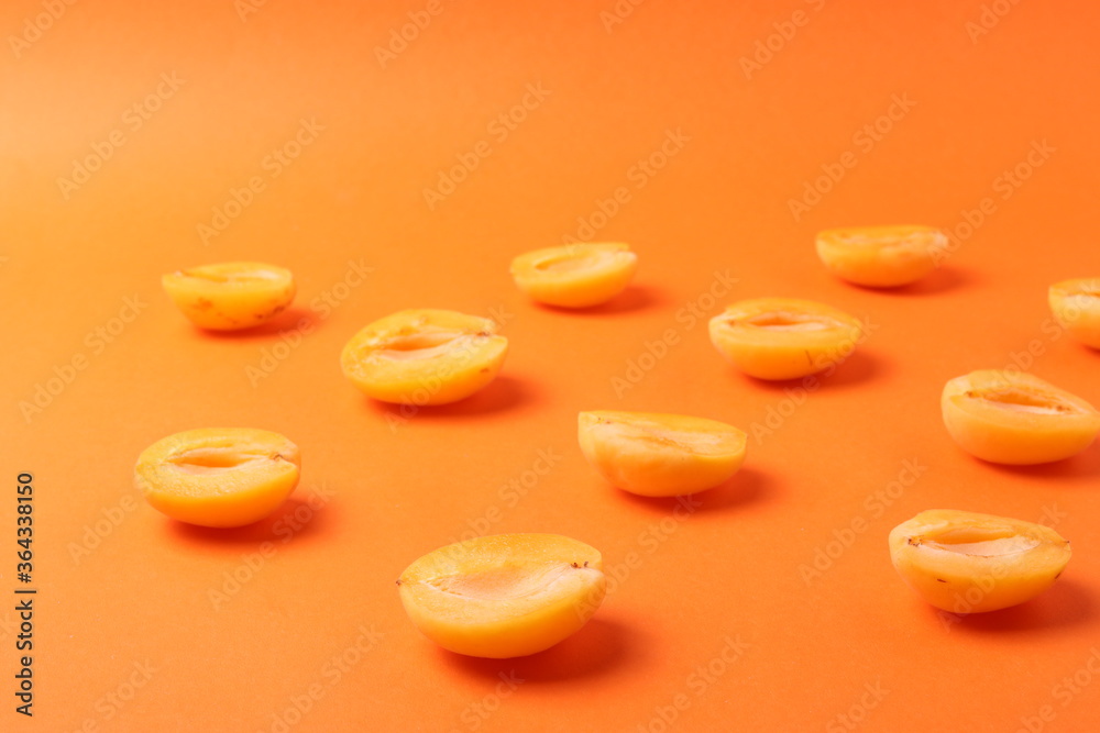background pattern style shot of several orange ripen apricots with seeds on the bright orange color background background pattern style shot of several orange ripen apricots with seeds on the bright orange color background