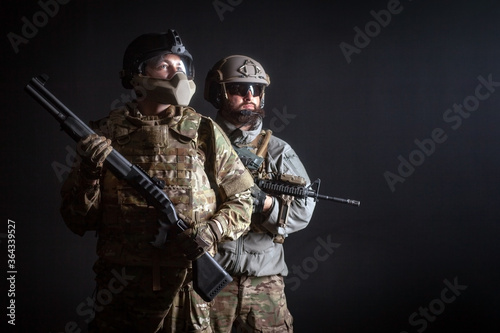 Fotografie American special forces, two soldiers in military uniform with weapons on a dark