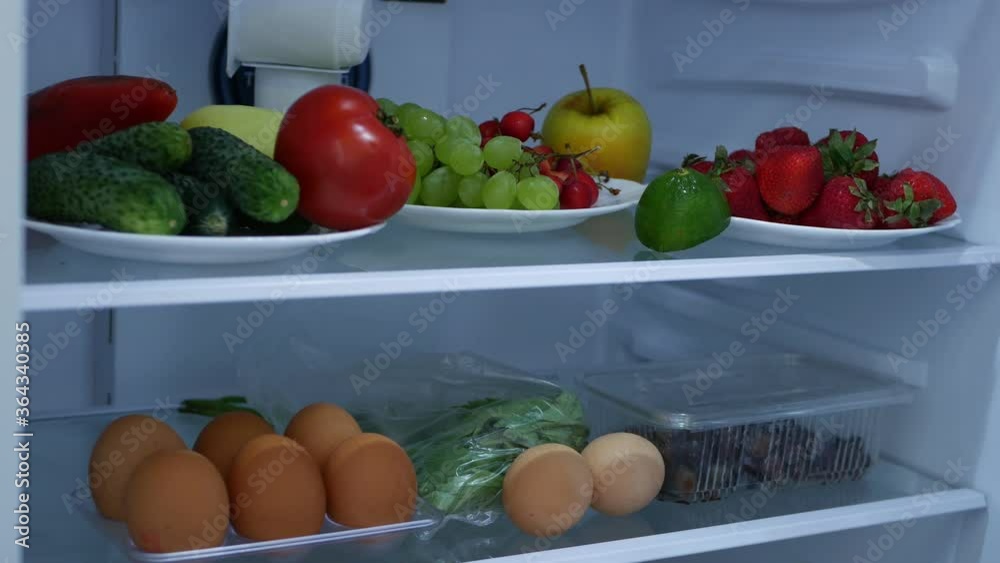 Image with a Man Opening the Refrigerator Door Looking for Fresh Fruits and Vegetables Image with a Man Opening the Refrigerator Door Looking for Fresh Fruits and Vegetables