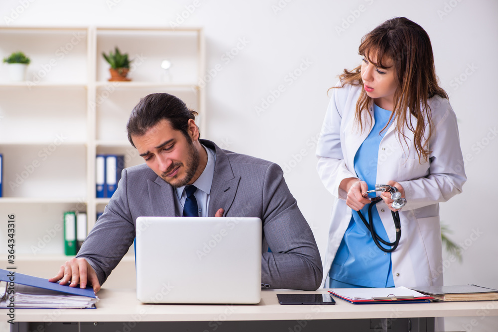 Young female doctor and sick businessman in the office Young female doctor and sick businessman in the office