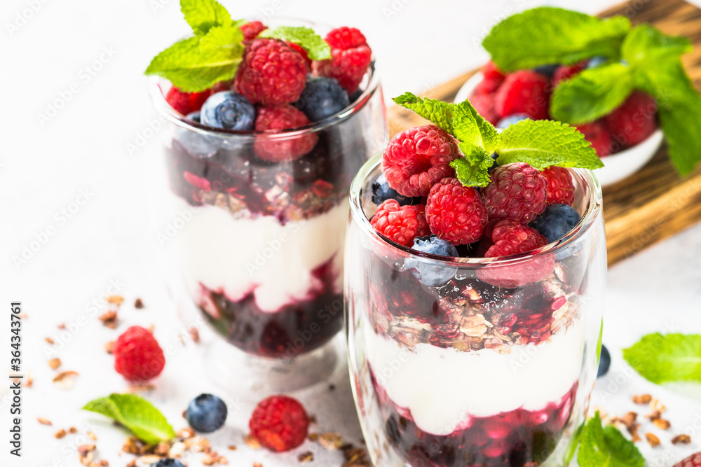 Parfait with granola, jam and fresh berries in the glass jar. Parfait with granola, jam and fresh berries in the glass jar.