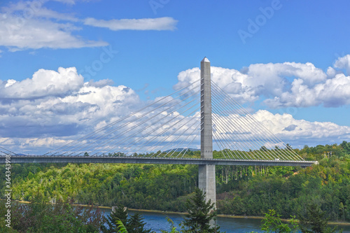 Bucksport, Maine, USA: White clouds in a bright blue sky over the Penobscot Narrows Bridge. The bridge is a 2,120 ft. long cable-stayed bridge over the Penobscot River.