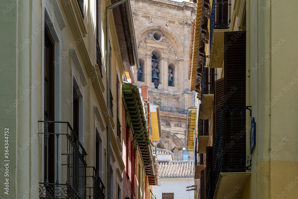 Tower of the cathedral of Granada seen from the narrow Sillería street