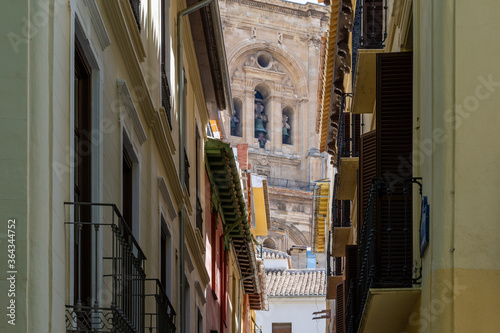 Tower of the cathedral of Granada seen from the narrow Sillería street