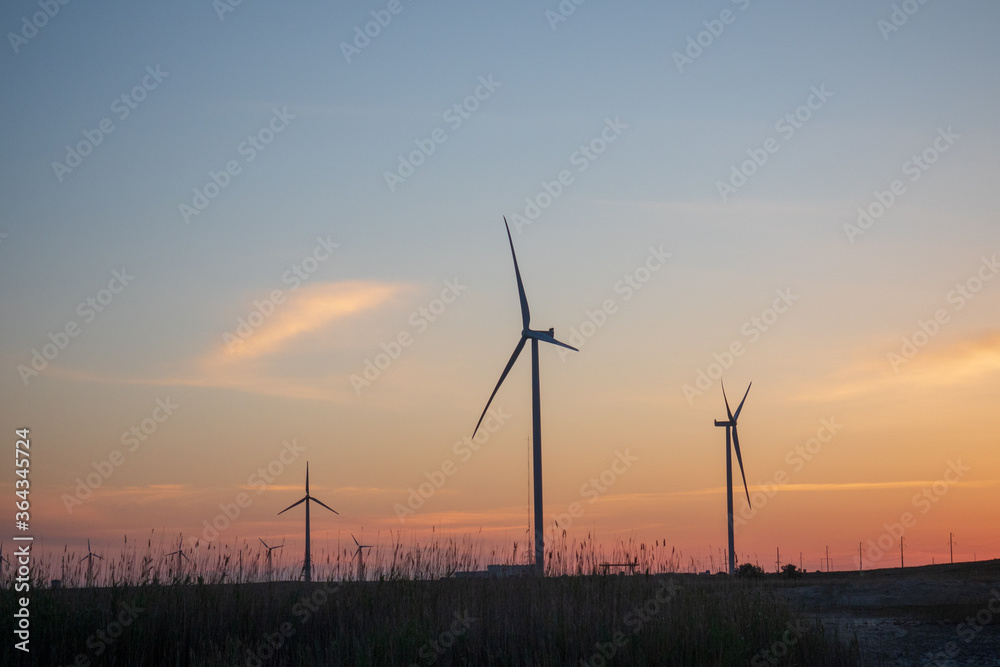 Wind generators turbines. Beautiful landscape at sunset. Green renewable energy