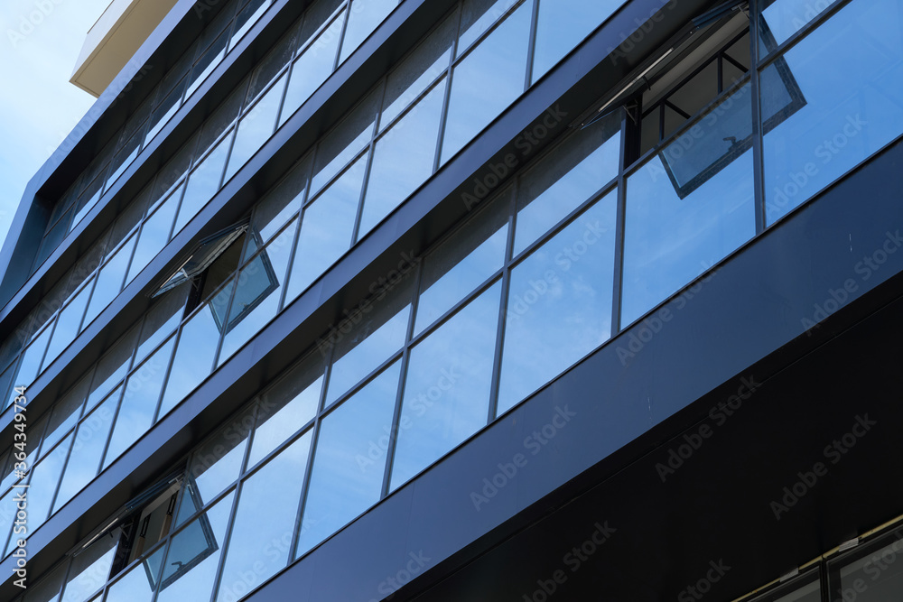 facade of a modern building on a bright Sunny day, blue sky and clouds reflecting in a glass, beautiful exterior of the new building facade of a modern building on a bright Sunny day, blue sky and clouds reflecting in a glass, beautiful exterior of the new building