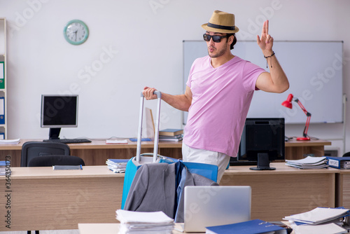 Young male employee preparing for the trip photo