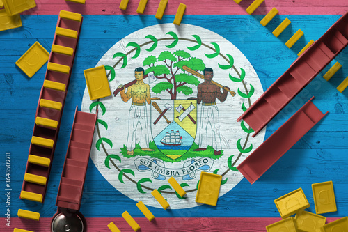 Belize flag with national background with dominoes on wooden table. Top view. Concept of game.