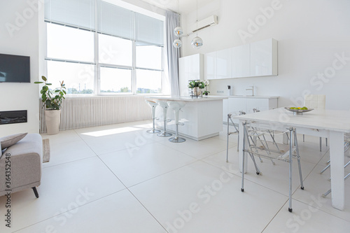 Cozy luxury modern interior design of a studio apartment in extra white colors with fashionable expensive furniture in a minimalist style. white tiled floor, kitchen, relaxation area and workplace © 4595886