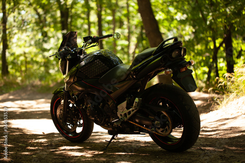 Sports black motorcycle on a background of an underground gray wall in the studio.