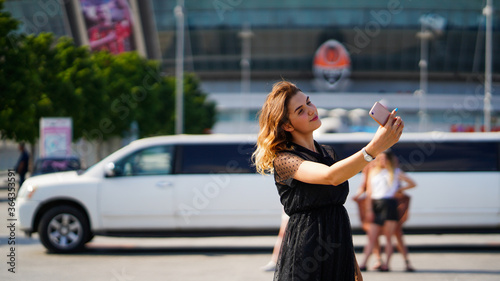 Young beautiful woman with loose brawn hair holding phone