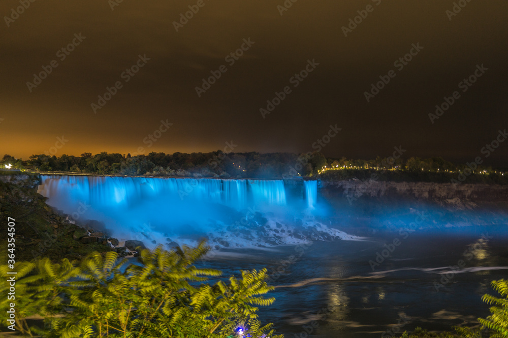 Thunderous Niagara waterfalls in night with colorful lights in Niagara, Ontario, Canada