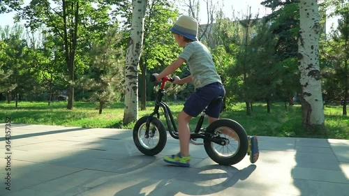 6 years old boy riding a runbike in a park photo