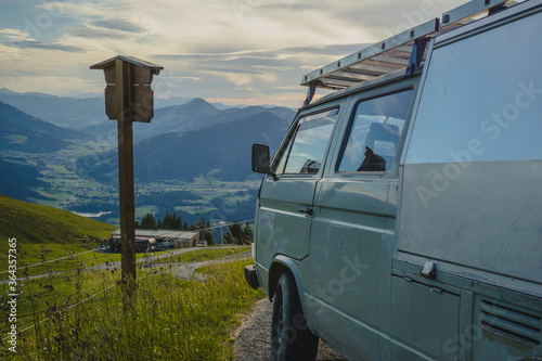 Looking down towards Kitzbuhel aki area and other mountains from the high Kitzbuheler horn on a sunny summer day with a vintage campervan in foreground photo