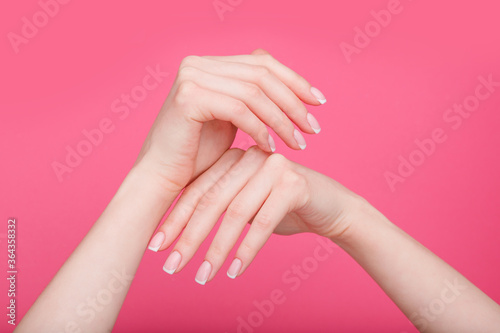 Beautiful female hands with stylish nail manicure gel polish on pink  background. Free space for text.