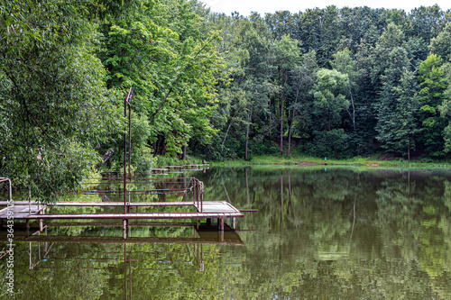 Forest and bridges for fishing are reflected on the surface of the reservoir