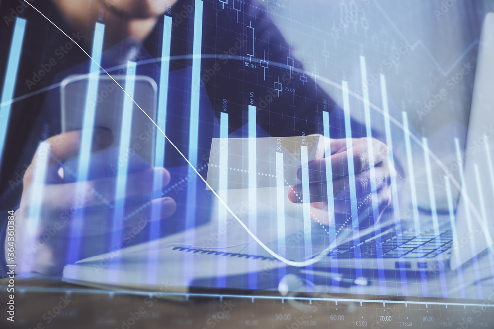 Double exposure of man's hands holding and using a phone and financial graph drawing. Analysis concept. Double exposure of man's hands holding and using a phone and financial graph drawing. Analysis concept.