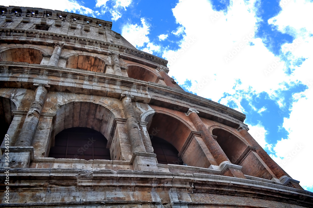 Looking up at the Colosseum in Rome under a beautiful blue sky