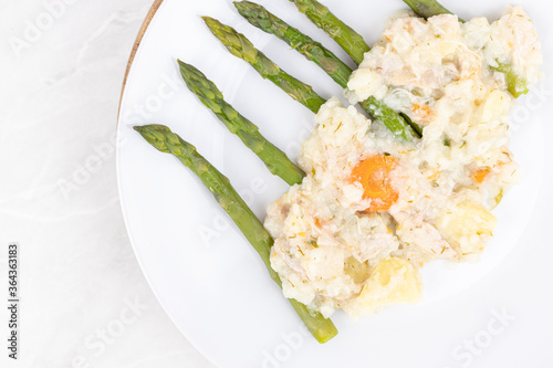 Cooked asparagus witl dill sauce served on the plate photo