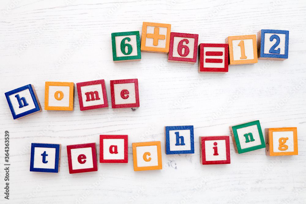 A set of children’s colourful wooden spelling blocks spell out the words ‘home teaching’. A set of children’s colourful wooden spelling blocks spell out the words ‘home teaching’.