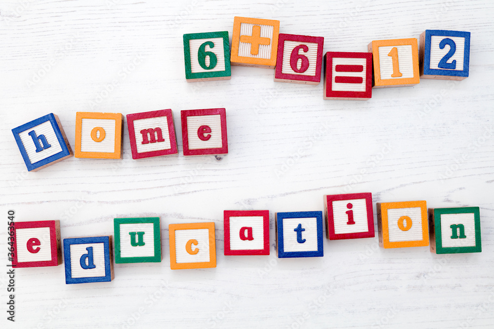 Children’s wooden spelling blocks spell out the words home education and a simple sum. Children’s wooden spelling blocks spell out the words home education and a simple sum.