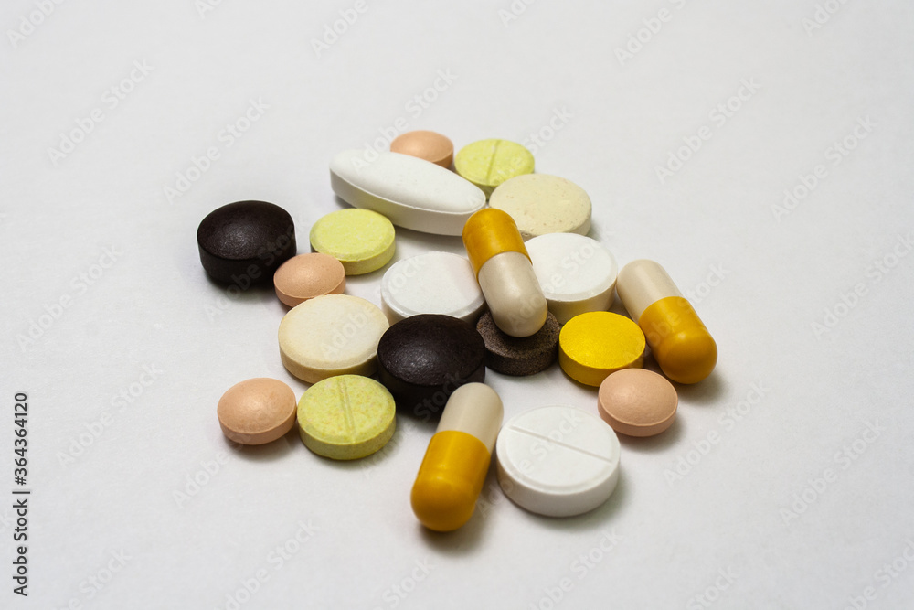 Colorful pills and capsules on white background close up, macroshot tablets, isolated. Pandemic medications. Drugs disease treatment - covid-19, coronavirus. Vitamins for human health Colorful pills and capsules on white background close up, macroshot tablets, isolated. Pandemic medications. Drugs disease treatment - covid-19, coronavirus. Vitamins for human health