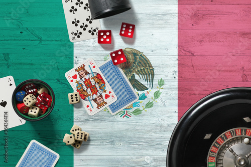 Mexico casino theme. Aces in poker game, cards and chips on red table with national wooden flag background. Gambling and betting. photo