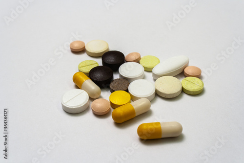 Bunch colorful pills and capsules on a white background close up, macroshot tablets, isolated. Pandemic medications. Drugs disease treatment - covid-19, coronavirus. Vitamins for human health