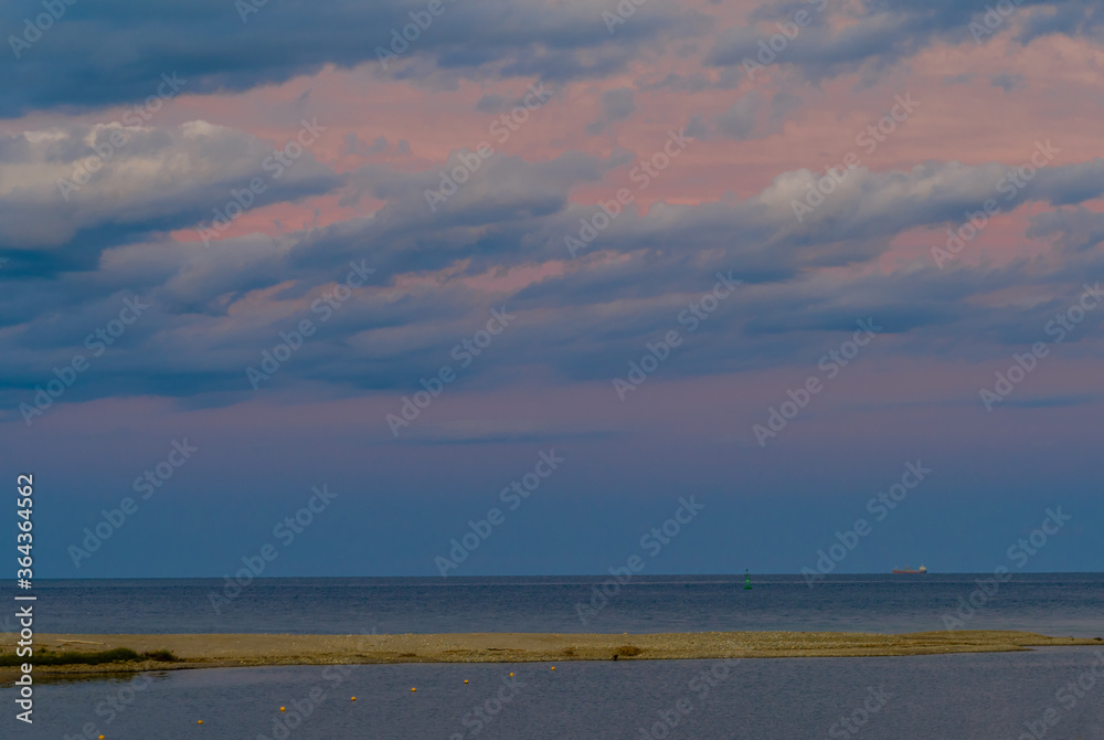 Seascape of sandbar under blue evening sky